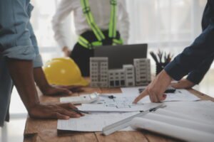 Construction and structure concept of Engineer or architect meeting for project working with partner and engineering tools on model building and blueprint in working site, contract for both companies.